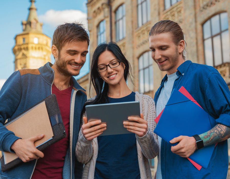 a-group-of-young-multi-ethnic-group-of-student-in-university-smiling-and-looking-at-the-tablet.jpg